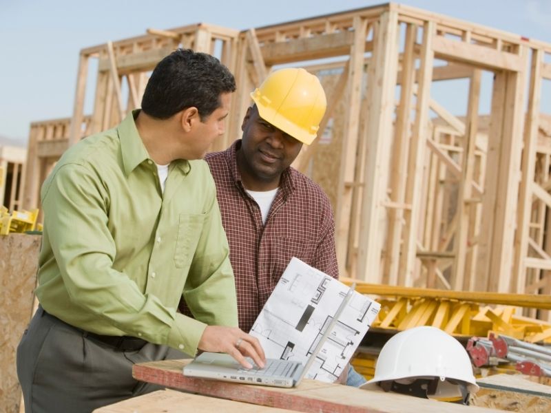Construction professionals reviewing plans during a warehouse expansion project supported by construction survey services.